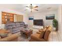 Cozy living room featuring neutral tones, a ceiling fan, and bright natural light at 5618 E Des Moines St, Mesa, AZ 85205