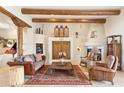 Inviting living room featuring a cozy fireplace, comfortable seating, and beautiful decorative accents and travertine floors at 6432 E Old Paint Trl, Carefree, AZ 85377