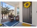 Inviting front porch featuring two cushioned chairs, a small table, and a decorative wreath on the front door at 759 E Zesta Ln # 104, Gilbert, AZ 85297