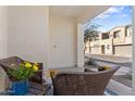 Inviting covered front porch featuring wicker chairs, a blue rug, and desert landscaping at 759 E Zesta Ln # 104, Gilbert, AZ 85297