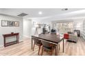 Bright living room featuring a dining area, light wood floors, and sliding glass doors to a private balcony at 7830 E Camelback Rd # 108, Scottsdale, AZ 85251