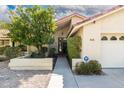 Inviting home entrance with desert landscaping, a walkway, and a two-car garage at 817 E Meadow Ln, Phoenix, AZ 85022