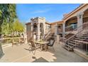 Outdoor patio featuring tan-colored stucco, a wrought iron fence, and a table with four chairs at 9151 W Greenway Rd # 258, Peoria, AZ 85381