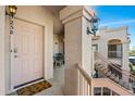 Front door entrance of condo featuring a welcome mat, light fixture, and stucco pillar at 9151 W Greenway Rd # 258, Peoria, AZ 85381