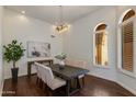 Dining area with a wooden table, upholstered chairs, modern lighting, and a large window with shutters at 9214 N 83Rd St, Scottsdale, AZ 85258