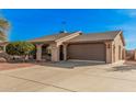 Single level home showcasing desert landscaping, a two car garage, and a front entrance with gate at 9283 W Rafael Dr, Arizona City, AZ 85123