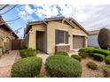 A well-kept home displaying verdant bushes and a neutral color scheme, complete with a two-car garage at 9610 E Trent Ave, Mesa, AZ 85212