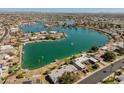 Expansive aerial view of a waterfront neighborhood with lush landscaping and community lake at 10116 W Bolivar Dr, Sun City, AZ 85351