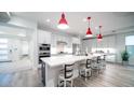 Modern kitchen boasts white cabinets, stainless steel appliances, quartz countertops, and eye-catching red pendant lighting at 11673 N 136Th St # 1005, Scottsdale, AZ 85259