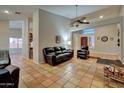 Open-concept living room with terracotta tile floors, comfortable seating, and a view of the entryway at 13601 S 37Th St, Phoenix, AZ 85044