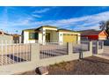 Street view of a single-story home featuring a white picket fence, gravel landscaping, and a yellow two-car garage at 1625 S 113Th Ave, Avondale, AZ 85323