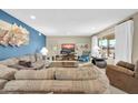 Spacious living room featuring plush seating, a large window, a TV, and stylish decor for comfortable living at 17807 N 126Th Dr, Sun City West, AZ 85375