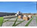 Backyard with a paver patio, outdoor fireplace, decorative plantings and privacy wall at 18429 W Mohave St, Goodyear, AZ 85338