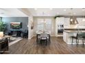 Open-concept dining area with wood floors next to a living room and a gourmet kitchen at 1929 S Follett Way, Gilbert, AZ 85295