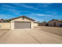 Wide two car garage and driveway in front of the house with low maintenance landscaping at 2110 W Behrend Dr, Phoenix, AZ 85027