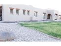 Beautiful home exterior with desert landscape, featuring low-maintenance gravel, grass, and architectural windows at 2113 E Glencove St, Mesa, AZ 85213