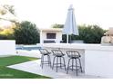 Outdoor bar with seating, umbrella, and easy access to the pool and entertainment area at 2113 E Glencove St, Mesa, AZ 85213