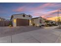 Attractive single-Gathering home featuring a two-car garage, desert landscaping, and a paved driveway at dusk at 22837 E Silver Creek Ln, Queen Creek, AZ 85142