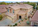 Aerial view of a two-story home with a tile roof, a two-car garage, and desert landscaping at 2527 W Amber Sun Dr, Phoenix, AZ 85085