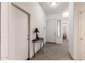 Inviting hallway featuring neutral tones, tile flooring, and ample natural light filtering through the entryway at 26826 N 66Th Ln, Phoenix, AZ 85083