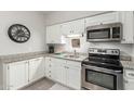 Modern kitchen featuring granite counters, white cabinets, and stainless steel appliances at 355 E Thomas Rd # B110, Phoenix, AZ 85012
