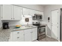Modern kitchen featuring granite counters, white cabinets, and stainless steel appliances at 355 E Thomas Rd # B110, Phoenix, AZ 85012