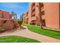 Scenic view of the building exterior with landscaped pathway, palm trees, and well-kept grounds at 4303 E Cactus Rd # 408, Phoenix, AZ 85032