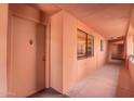 Hallway featuring neutral tones, a window, and access to units, offering a clean and functional space at 4303 E Cactus Rd # 408, Phoenix, AZ 85032