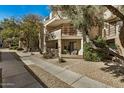 Condo exterior featuring balconies, mature trees, and a pedestrian walkway at 4850 E Desert Cove Ave # 251, Scottsdale, AZ 85254
