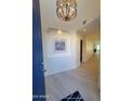 Bright foyer with modern chandelier and desert-themed artwork at 6411 S River Dr # 53, Tempe, AZ 85283