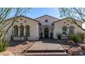 Charming home with arched windows, desert landscaping, and a welcoming front entrance with brick paver walkway at 9183 W Foothill Dr, Peoria, AZ 85383