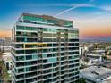 Modern high-rise building with sleek glass facade, city views, and parking area at 1 E Lexington Ave # 1211, Phoenix, AZ 85012