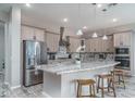 Bright kitchen with stainless steel appliances, light wood cabinets, and a center island with bar stool seating at 15233 W Baden St, Goodyear, AZ 85338