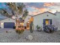 Charming home exterior featuring desert landscaping, a palm tree, and a welcoming arched entryway at 15837 W Bonitos Dr, Goodyear, AZ 85395