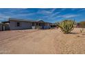 Single-story home with desert landscaping, carport, and spacious driveway at 1612 N 201St Ave, Buckeye, AZ 85396