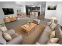 Open-concept living room with modern furnishings flowing into dining area and kitchen with island at 16472 W Tether Trl, Surprise, AZ 85387