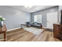 Cozy living room with wood floors, gray sofa, area rug, and natural light at 16585 W Harrison St, Goodyear, AZ 85338