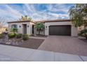 Charming single-story home featuring desert landscaping, a brick driveway, and a two-car garage at 1697 E Tangelo Pl, Queen Creek, AZ 85140