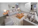 Cozy living room featuring a sofa, arm chairs, a rug, and staircase to upper level at 17699 W Tonto St, Goodyear, AZ 85338