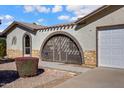 Close-up of a home's courtyard featuring desert landscaping and an arched entrance at 1812 W Curry Drive Dr, Chandler, AZ 85224