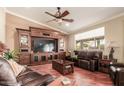 Comfortable living room with large entertainment center, hardwood floors, and a large window for natural light at 24413 S Lakeway Sw Cir, Sun Lakes, AZ 85248