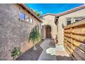 Inviting entrance with an arched wood door and desert landscaping, creating a warm and welcoming first impression at 27709 N 129Th Ln, Peoria, AZ 85383