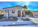 Charming home featuring a stucco exterior, arched entryway, and desert landscaping with a blue sky above at 27709 N 129Th Ln, Peoria, AZ 85383