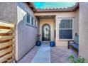 Welcoming front porch with a stylish black front door, potted flowers, and a comfortable bench at 27709 N 129Th Ln, Peoria, AZ 85383