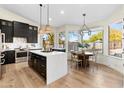 Modern kitchen with a large center island, pendant lighting, stainless steel appliances, and hardwood flooring at 29399 N 67Th Way, Scottsdale, AZ 85266