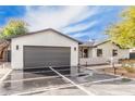 Modern home featuring a spacious driveway with decorative concrete, a two-car garage, and clean, white stucco at 3033 E Roma Ave, Phoenix, AZ 85016