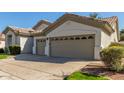 A spacious two-car garage on a well-kept property, enhanced by lush green landscaping at 3751 S Vista Pl, Chandler, AZ 85248