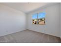 Bright bedroom with neutral carpet, white walls, and a window offering neighborhood views at 4093 W Eli Dr, San Tan Valley, AZ 85144