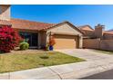 Charming single-Gathering home featuring a two-car garage, beautiful landscaping, and a classic desert tile roof at 4226 E Jojoba Rd, Phoenix, AZ 85044