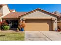 Charming single-Gathering home featuring a two-car garage, beautiful landscaping, and a classic desert tile roof at 4226 E Jojoba Rd, Phoenix, AZ 85044